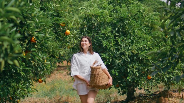 Donna felice che passeggia nel giardino di luce solare arancione giovane donna che cammina nel verde lussureggiante