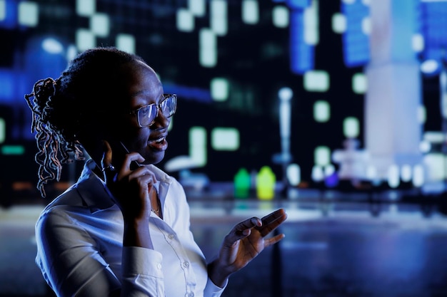 Donna felice che passeggia per il paesaggio cittadino durante la notte, che si diverte a chiacchierare al telefono con la migliore amica, che torna a casa dal lavoro, che fa telefonate mentre va e viene.