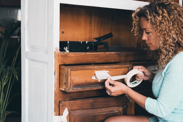 Donna felice che ripristina l'armadietto dei mobili a casa come terapia rilassante per la sola salute della mente Tipico lavoro tuttofare fatto da persone di sesso femminile Ristrutturazione per un nuovo concetto di vita Rinnovo indoor nuova casa adulta signora