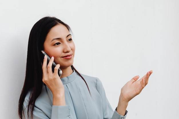 Donna felice che risponde al telefono cellulare su sfondo bianco