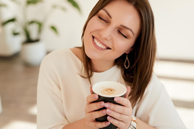 Donna felice che si gode il caffè al mattino