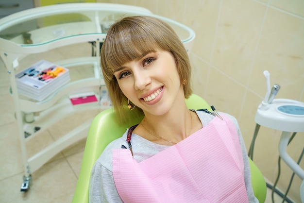 Donna felice che si siede nell&#39;ufficio del dentista, denti sani.