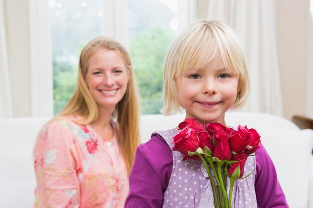 Donna felice che tiene le rose rosse con la figlia