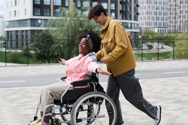 Donna felice con disabilità che si diverte con la sua amica all'aperto