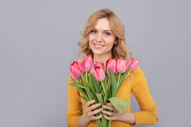 Donna felice con i tulipani signora tenere fiori per le vacanze di primavera ragazza con bouquet