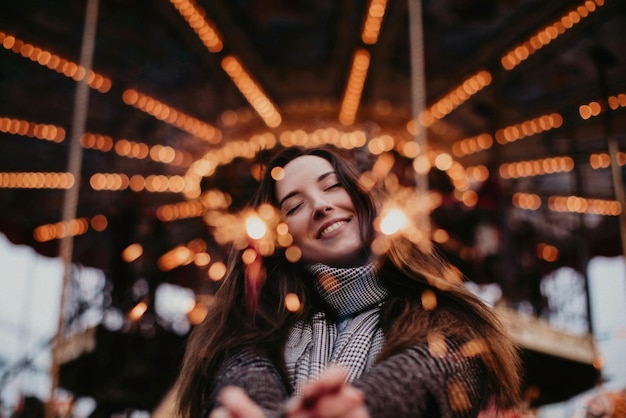 Donna felice con scintilli di Natale sullo sfondo di luci d'oro per le vacanze di Capodanno