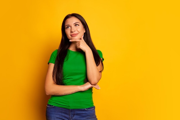 Donna felice con sogni sorridenti isolati su sfondo giallo alla moda studio bella femmina