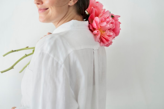 Donna felice con un mazzo di peonia corallina al tramonto