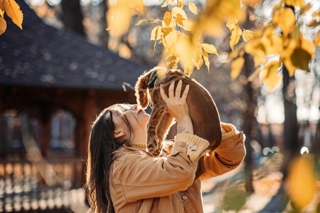 Donna felice con un simpatico cucciolo di cocker spaniel inglese in una passeggiata nella foresta in autunno Proprietario di cane e donna felice che gioca nel parco in autunno