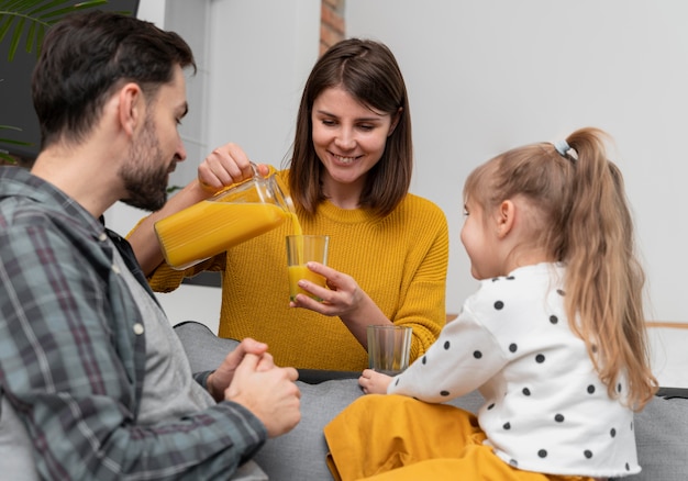 Donna felice del colpo medio che versa il succo