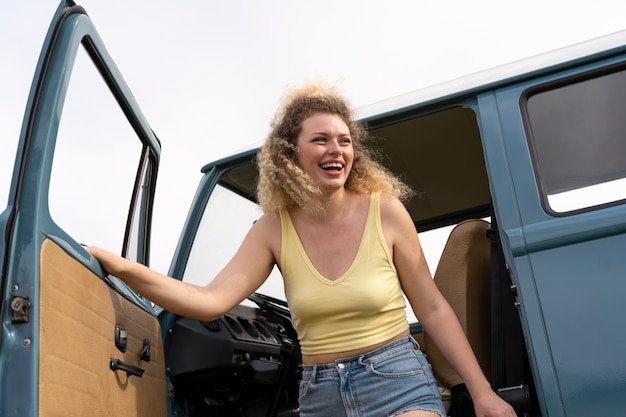 Donna felice del tiro medio con furgone