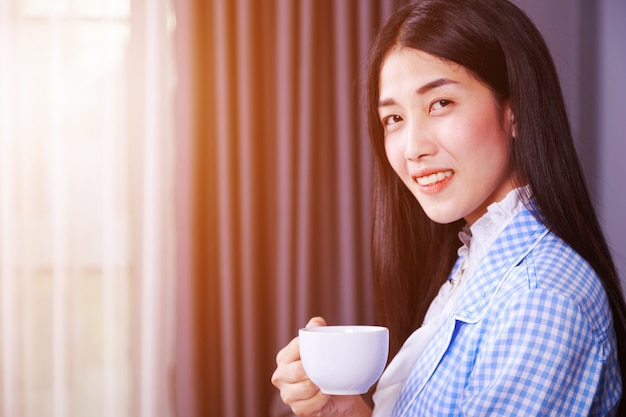 donna felice di affari con caffè o una tazza di tè