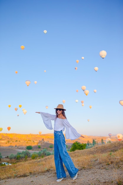 Donna felice durante l'alba guardando i palloni ad aria calda in cappadocia turchia