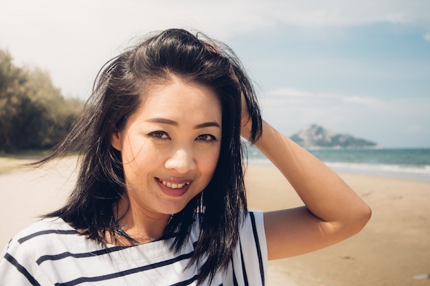 Donna felice e giocosa che cammina sulla spiaggia.