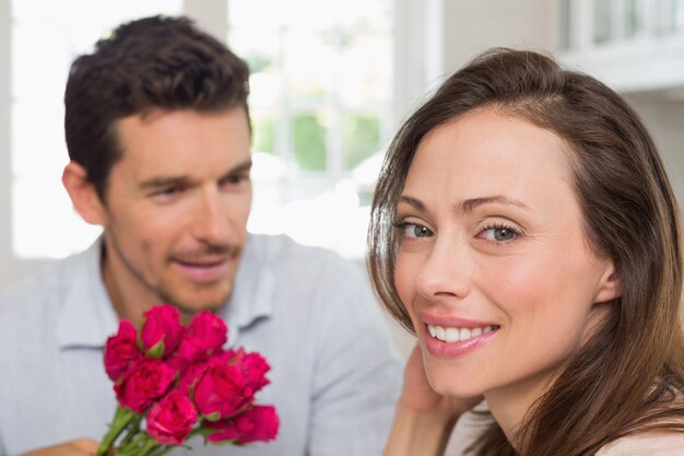 Donna felice e uomo con i fiori a casa