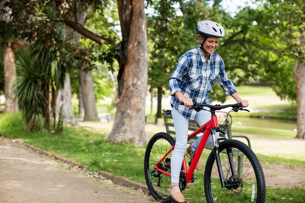 Donna felice in bicicletta nel parco