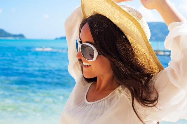 Donna felice in cappello sulla spiaggia