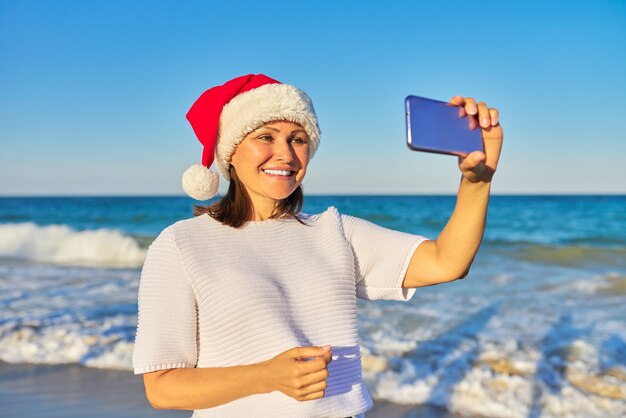 donna felice in santa cappello sulla spiaggia