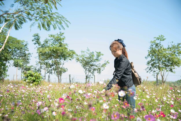 Donna felice nel campo di bellezza con fiori cosmo