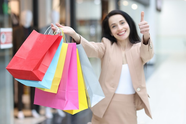 Donna felice nel centro commerciale con il primo piano dei pacchetti