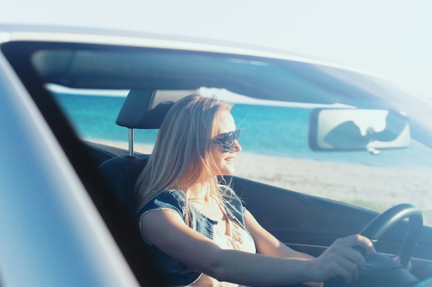 Donna felice rilassata che viaggia in auto