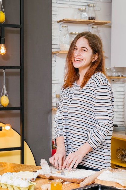 Donna felice sorridente che cuociono i biscotti in cucina