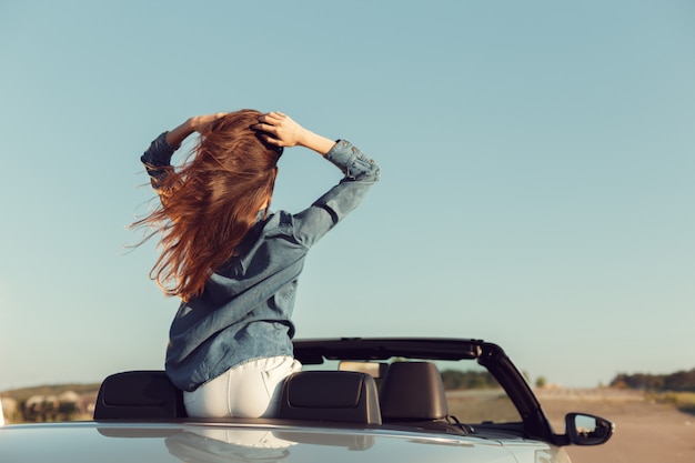 Donna felice viaggiatore in auto cabrio