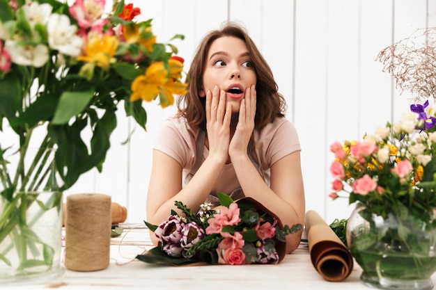 Donna fiorista scioccata che lavora con i fiori