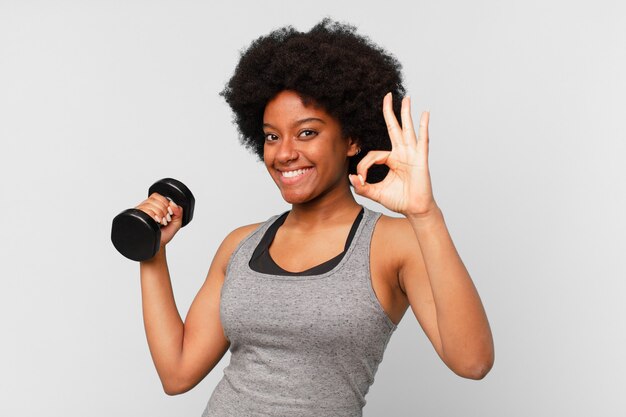 Donna fitness afro nera con manubri