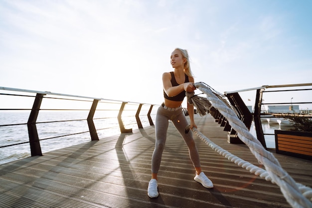 Donna fitness che fa esercizi sportivi al molo della spiaggia Stile di vita sano Sport Vita attiva