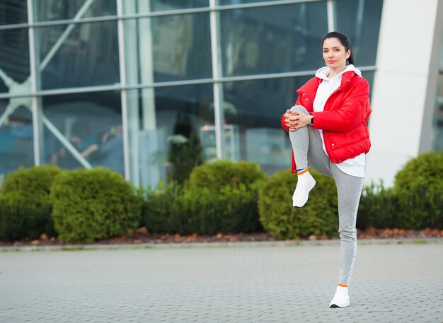 Donna fitness facendo allenamento in piedi in uno sfondo dello stadio.