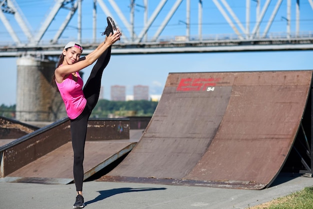 Donna fitness facendo esercizi di stretching su sfondo urbano della città