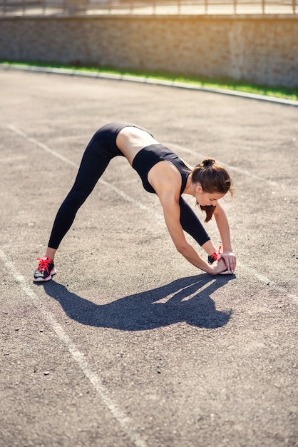 Donna fitness facendo stretching sul sadium prima dell'allenamento