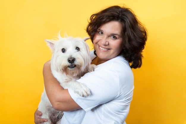 donna formosa in sfondo giallo con il suo cane