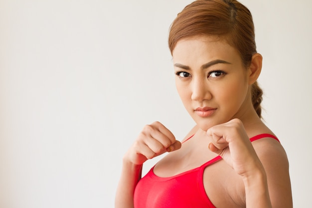 donna forte che pratica arti marziali, assumendo combattimenti o guardia di boxe