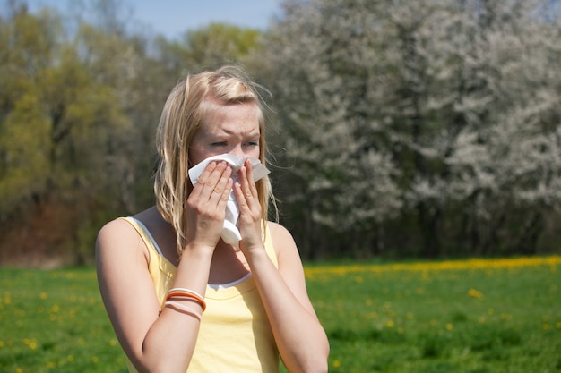 Donna fredda o malata con allergia, che soffia muco