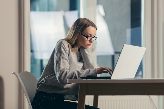 donna freelance stanca di lavorare di notte su un laptop completa il lavoro fino a tardi