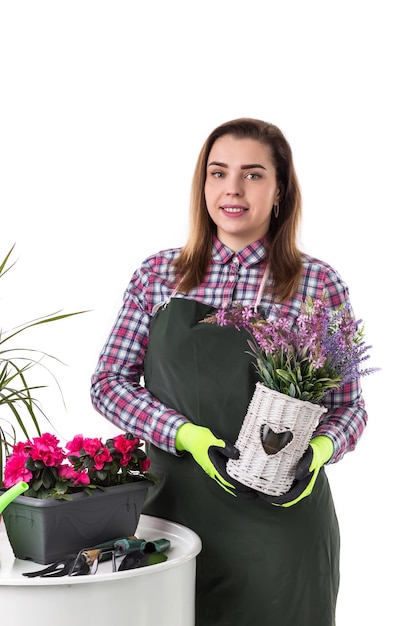 Donna giardiniere professionista o fiorista in grembiule azienda fiori in una pentola e attrezzi da giardinaggio isolati su sfondo bianco Copia spazio
