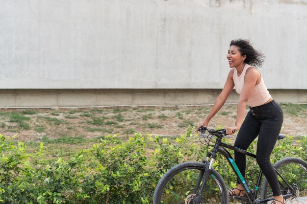 Donna gioiosa in bicicletta in una giornata di sole