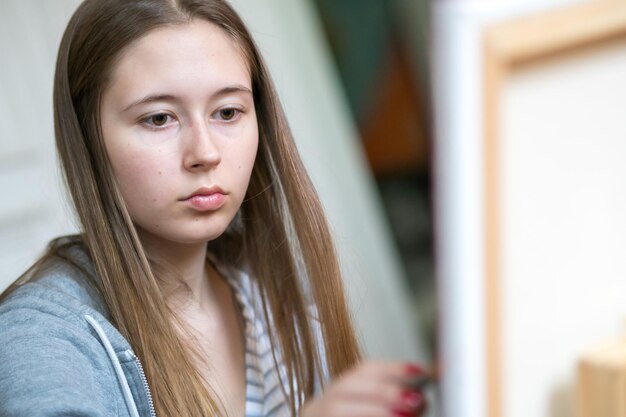 Donna giovane concentrata che dipinge su tela