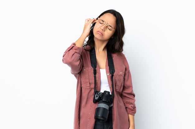 Donna giovane fotografo sopra il muro bianco con mal di testa