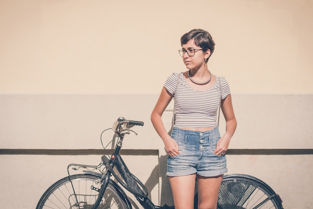 donna giovane hipster con bici