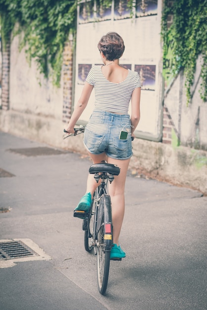 donna giovane hipster con bici