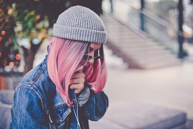 Donna giovane hipster con capelli e cappello rosa