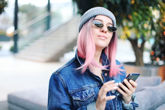 Donna giovane hipster con capelli rosa e cappello