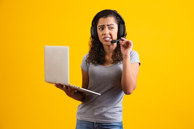 Donna giovane receptionist che lavora con notebook e auricolare.