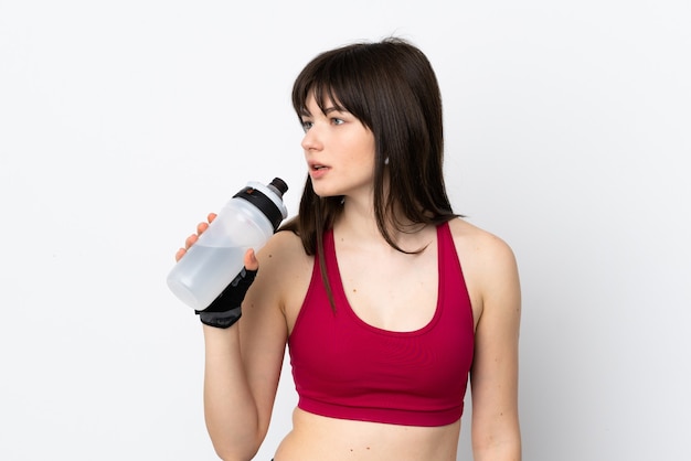 Donna giovane sport isolata sul muro bianco con bottiglia d'acqua sportiva