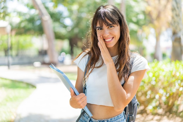 Donna giovane studente all'aperto che bisbiglia qualcosa