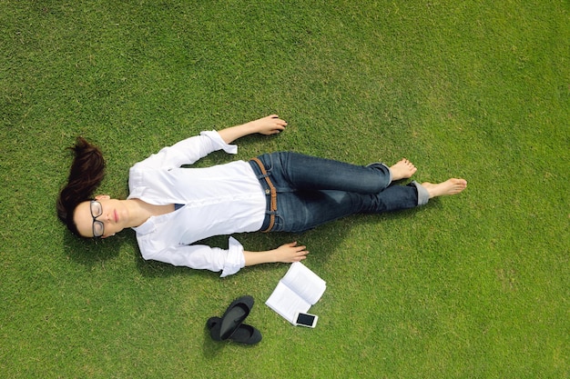 Donna giovane studente che legge un libro e studia nel parco