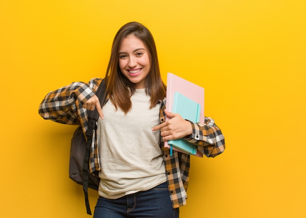 Donna giovane studente che punta verso il basso con le dita